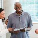 Man with daughter and doctor looking at pamphlet