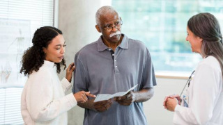 Man with daughter and doctor looking at pamphlet