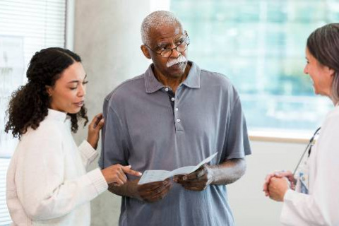 Man with daughter and doctor looking at pamphlet