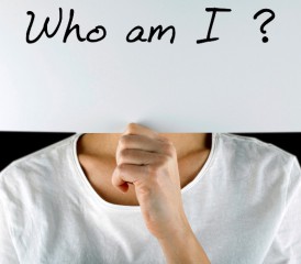 Person holding sign that says Who Am I?