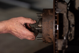 Man's hand fixing the brakes of a car