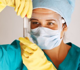 Researcher in scrubs looks at test tube sample