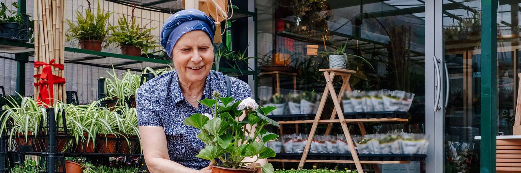 Cancer survivor admiring a flower at a plant nursery