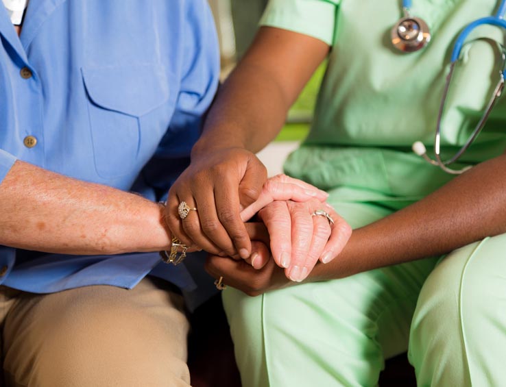 Home healthcare nurse holds senior woman's hands. Consoling. Kindness. Home healthcare nurse holds senior woman's hands. Consoling. Kindness.