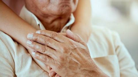 Elderly man with hands on his chest