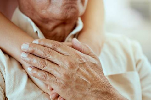 Elderly man with hands on his chest