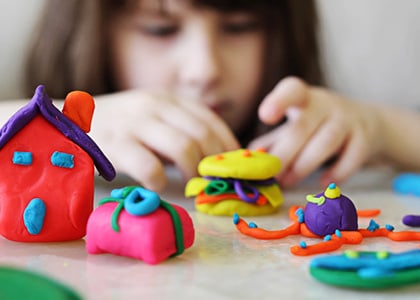 Little girl playing with clay