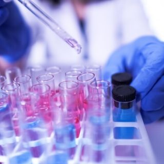 Hands in blue gloves with test tubes