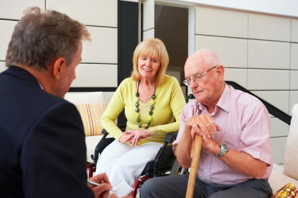 elderly man and woman sitting and talking to a business man