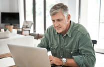 Older man viewing webinar on a laptop