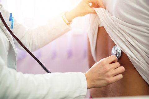 Doctor checking lungs with stethoscope