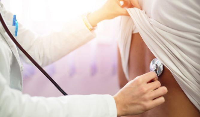 Doctor checking lungs with stethoscope