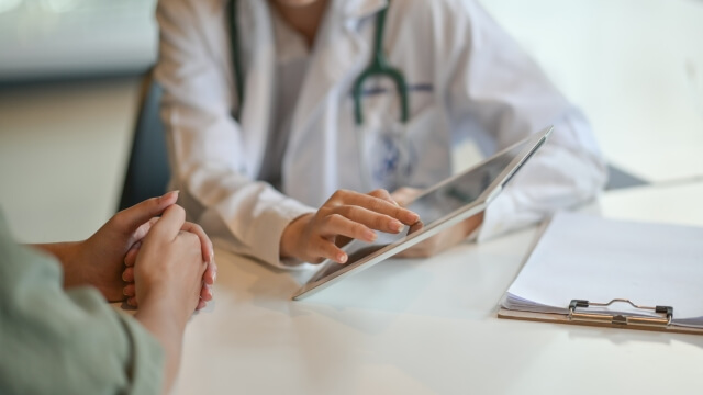 Doctor with female patient and tablet