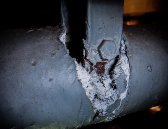 Section of exposed asbestos pipe insulation