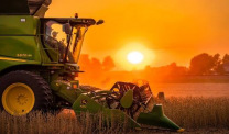 Farm machinery in field at sunset