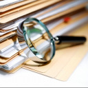 stack of file folders with magnifying glass