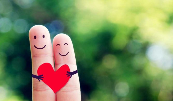 Happy loving fingers holding red heart