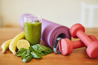 Smoothie, spinach yoga mat and dumbbells