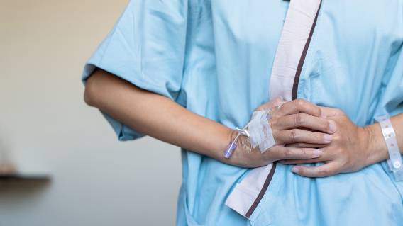 Patient holding stomach after surgery