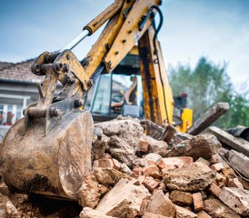 Tractor demolishing a house