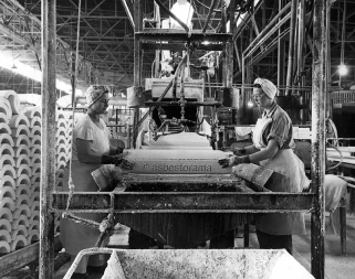 Two female Johns-Manville factory workers working with asbestos pipe insulation