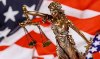 Justice statue with American flag background