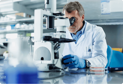 Lab technician using a microscope in a laboratory