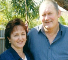 Lorraine Kember and Brian Kember smiling in front of tree