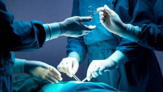 Surgeons in blue with medical instruments
