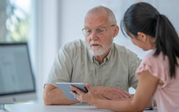 Woman showing male patient iPad
