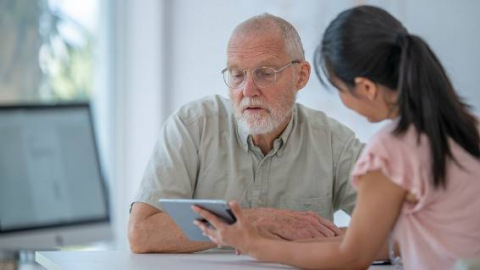 Woman showing male patient iPad