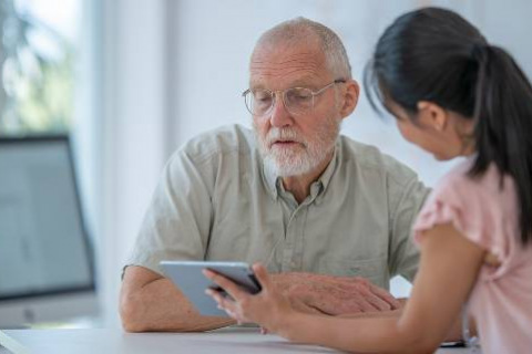 Woman showing male patient iPad