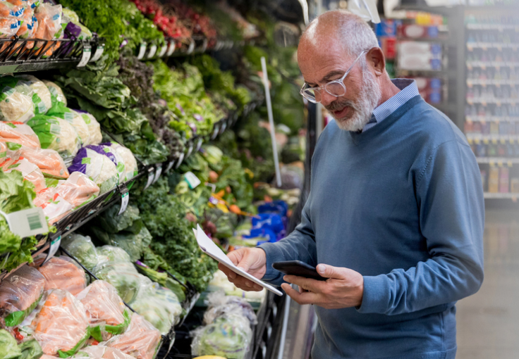 Older man shopping for vegetables in a grocery store