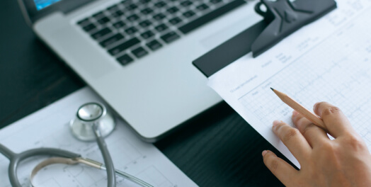 Doctor taking notes with laptop