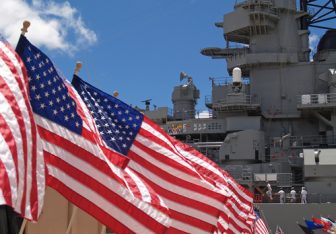 American flags in front of a U.S. Navy ship.