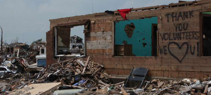 Building remnants standing among debris in Joplin, MO after a tornado.