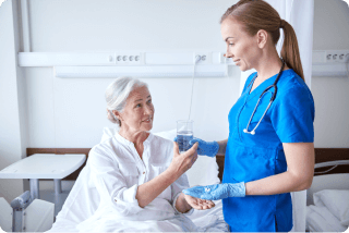 nurse giving patient medicine with water