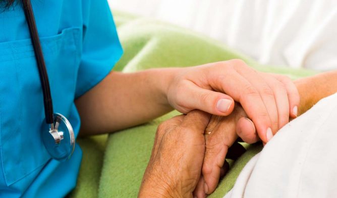 Nurse holding a patient's hands