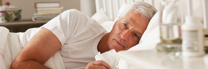 Older man lying awake in bed