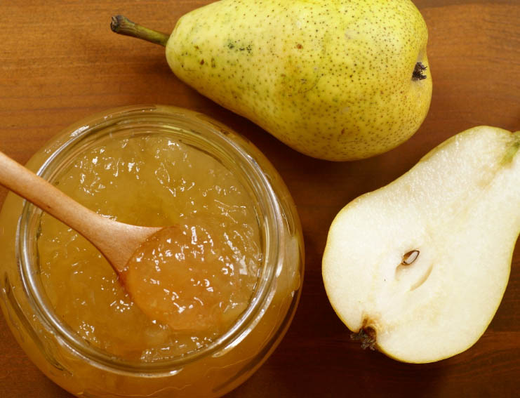 Pear jam with sliced pear on a wooden table Pear jam with sliced pear on a wooden table