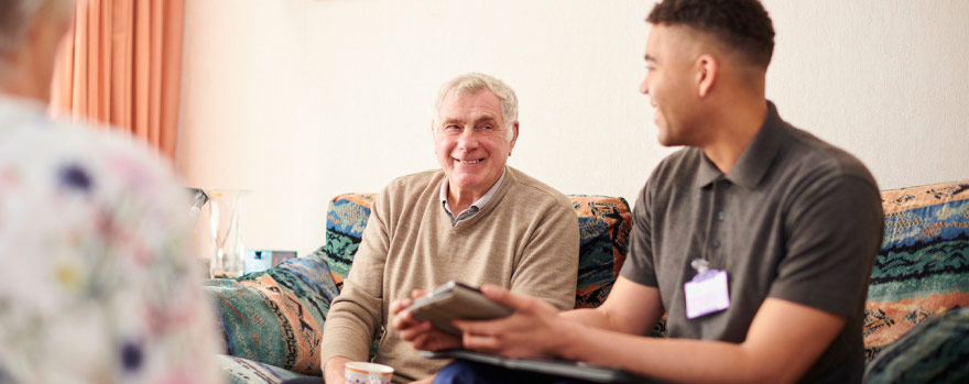 Older man speaking with a caretaker at an assisted living facility