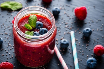 Red smoothie with blueberries and mint in glass