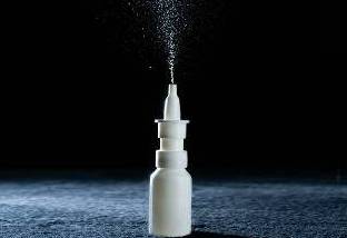 White nasal spray bottle with mist