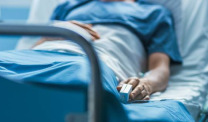 Patient in blue lying in hospital bed