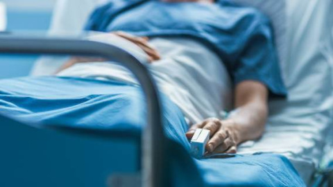 Patient in blue lying in hospital bed