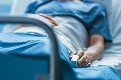 Patient in blue lying in hospital bed
