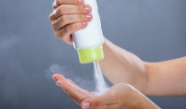 woman squeezing talcum powder into hand