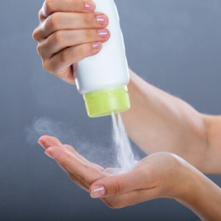 woman squeezing talcum powder into hand