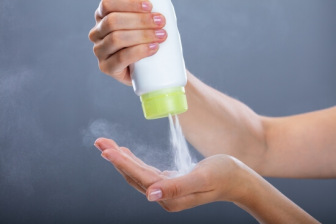 woman squeezing talcum powder into hand