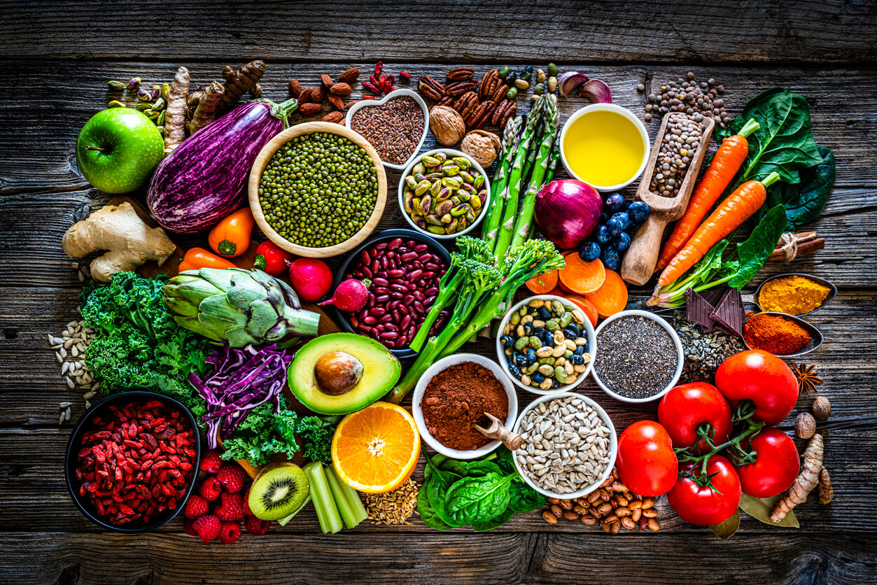 Vitamin rich fruits, vegetables, and seeds spread on a table.